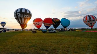 Sejumlah Balon udara lepas landas di pangkalan udara Chambley-Bussieres saat festival balon udara internasional ke-18 "Grand-Est Mondial Air Ballons" di Hageville, Prancis, Jumat (21/7/2023). [Jean-Christophe VERHAEGEN / AFP]
