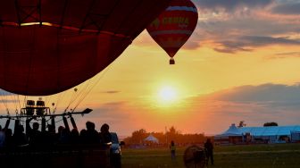 Sejumlah Balon udara terbang saat festival balon udara internasional ke-18 "Grand-Est Mondial Air Ballons" di Hageville, Prancis, Jumat (21/7/2023). [Jean-Christophe VERHAEGEN / AFP]