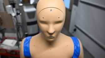 Robot ANDI berdiri di samping peralatan untuk memantau kondisi lingkungan saat penelitian tentang efek paparan gelombang panas pada tubuh manusia di Arizona State University (ASU), Phoenix, Arizona, Kamis (20/7/2023). [Patrick T. Fallon / AFP]