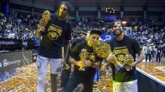 Pelatih tim Prawira Harum Bandung David R Singleton (tengah) didamping pebasket Jarred Dwayne Shaw (kiri) dan Brandone Francis (kanan) mencium tropi IBL 2023 seusai mengalahkan Pelita Jaya Bakrie Jakarta pada Final Indonesia Basket League (IBL) 2023 di GOR C-Tra Arena, Bandung, Jawa Barat, Sabtu (22/7/2023). [ANTARA FOTO/M Agung Rajasa]