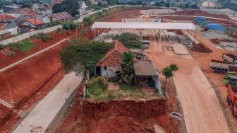 Foto udara rumah yang belum digusur pada proyek Jalan Tol Cijago seksi 3B yang menghubungkan wilayah Serpong,Cinere, dan Tol Jagorawi di Limo, Depok, Jawa Barat, Senin (24/7/2023). [ANTARA FOTO/Yulius Satria Wijaya].