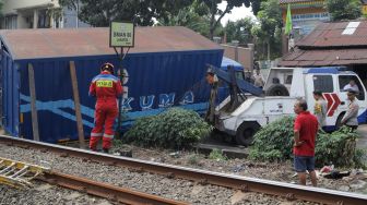 Petugas mengevakuasi truk yang menabrak tiang penyangga kabel KRL di antara Perlintasan Pondok Ranji - Kebayoran, Jakarta, Selasa (25/7/2023). [Suara.com/Alfian Winanto]