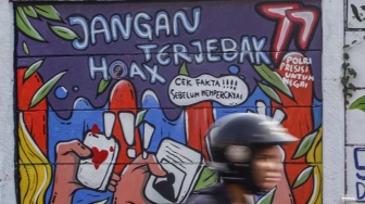 Pengendara melintas di depan mural bertemakan Pemilu di Jalan Raya Margonda, Depok, Jawa Barat, Jumat (28/7/2023). [ANTARA FOTO/Yulius Satria Wijaya].