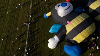 Pemandangan udara menunjukkan orang-orang menonton saat balon udara diluncurkan selama Festival Balon Tahunan New Jersey ke-40 di Bandara Solberg, Readington, New Jersey, Jumat (28/7/2023). [Julia Nikhinson / AFP]