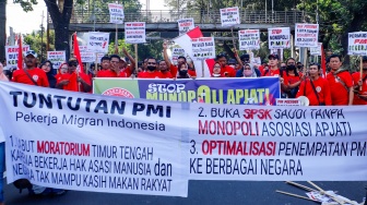 Massa yang tergabung dalam Solidaritas Perjuangan Pekerja Migran Indonesia melalukan aksi di sekitar Patung Kuda, Jakarta, Senin (31/7/2023). [Suara.com/Alfian Winanto]