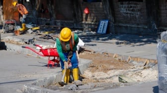 Pekerja saat menyelesaikan revitalisasi trotoar di kawasan Blok M, Jakarta Selatan, Selasa (1/8/2023).  [Suara.com/Alfian Winanto]