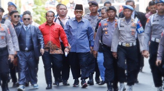 Pimpinan Pondok Pesantren Al Zaytun Panji Gumilang (tengah) berjalan saat akan menjalani pemeriksaan di Bareskrim Mabes Polri, Jakarta, Selasa (1/8/2023). [Suara.com/Alfian Winanto]