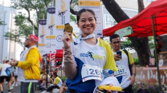 Peserta menunjukkan medali usai mengikuti gelaran Hukumonline Run 2023 di kawasan SCBD, Jakarta, Minggu (6/8/2023). [Suara.com/Alfian Winanto]