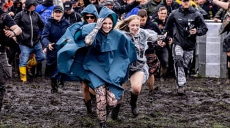 Para metalhead bersorak riang saat pembukaan festival musik Wacken Open Air 2023 di Wacken, Jerman, Rabu (2/8/2023). [Axel Heimken / AFP] 