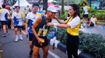 Peserta menerima medali usai mengikuti gelaran Hukumonline Run 2023 di kawasan SCBD, Jakarta, Minggu (6/8/2023). [Suara.com/Alfian Winanto]