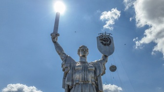 Gambar udara menunjukkan para pekerja sedang membongkar lambang bekas Uni Soviet dari perisai Monumen Ibu Pertiwi di Kyiv, Ukraina, Selasa (1/8/2023). [Sergii VOLSKYI/AFP]