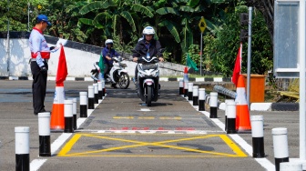 Peserta mengendarai sepeda motor saat ujian praktik SIM C di Satpas Polda Metro Jaya, Jalan Daan Mogot, Jakarta, Selasa (8/8/2023). [Suara.com/Alfian Winanto]
