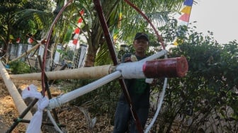 Pengrajin mengerjakan tahapan pembuatan batang  panjat pinang di kawasan, Manggarai, Jakarta, Senin (14/8/2023). [Suara.com/Alfian Winanto]