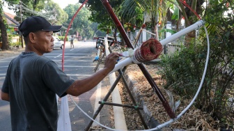 Pengrajin mengerjakan tahapan pembuatan batang  panjat pinang di kawasan, Manggarai, Jakarta, Senin (14/8/2023). [Suara.com/Alfian Winanto]