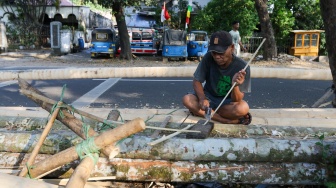 Pengrajin mengerjakan tahapan pembuatan batang  panjat pinang di kawasan, Manggarai, Jakarta, Senin (14/8/2023). [Suara.com/Alfian Winanto]