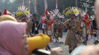 Sejumlah peserta Kirab Bendera Pusaka memakai baju adat berjalan menuju Istana Merdeka di Jakarta, Kamis (17/8/2023). [Suara.com/Alfian Winanto]