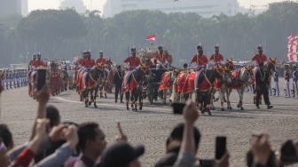 Pasukan berkuda mengiringi Kereta kencana yang membawa duplikat bendera pusaka merah putih dan teks proklamasi saat Kirab Bendera Pusaka menuju Istana Merdeka di Jakarta, Kamis (17/8/2023). [Suara.com/Alfian Winanto]