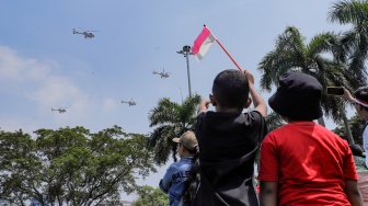 Warga melihat atraksi udara di atas langit Jakarta, Kamis (17/8/2023). [Suara.com/Alfian Winanto]