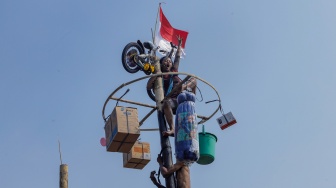 Peserta mengikuti lomba panjat pinang di Pantai Festival, Taman Impian Jaya Ancol, Jakarta, Selasa (17/8/2023). [Suara.com/Alfian Winanto]