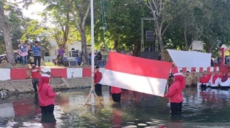 Unik, Warga Sumenep Rela Basah-basahan Upacara Bendera di Tengah Sungai