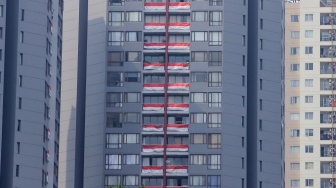 Puluhan bendera Merah Putih terpasang di balkon Apartemen Taman Rasuna, Kompleks Epicentrum, Jakarta, Jumat (18/8/2023). [Suara.com/Alfian Winanto]