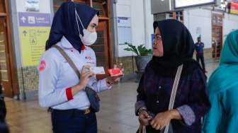 Petugas menawarkan Kartu Multi Trip (KMT) commuterline Edisi Khusus HUT RI ke-78 kepada penumpang di Stasiun Jakarta Kota, Jumat (18/8/2023). [Suara.com/Alfian Winanto]