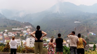 Penduduk setempat melihat kebakaran hutan yang melanda di Tenerife, Kepulauan Canary, Spanyol, Minggu (20/8/2023). [DESIREE MARTIN / AFP]
