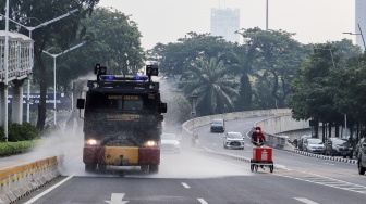 Mobil kepolisian melakukan penyiraman di kedua sisi di Jalan Jendral Sudirman hingga Patung Pemuda Membangun Senayan, Jakarta, Rabu (23/8/2023). [Suara.com/Alfian Winanto]