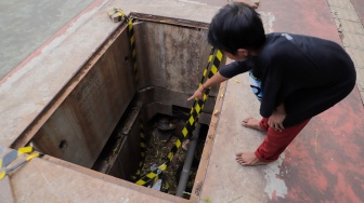 Warga menunjukkan dalamnya lubang saluran kabel di Jalan Raya Casablanca, Jakarta, Jumat (25/8/2023). [Suara.com/Alfian Winanto]