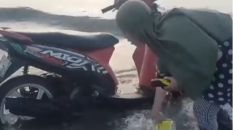 Viral Emak-emak Cuci Motor di Laut, Warganet Ngelus Dada: Jangan Dikasih Tahu Bang!