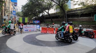 Pengemudi ojek online melintas di Jalan Blora, Jakarta Pusat, Kamis (31/8/2023). [Suara.com/Alfian Winanto]