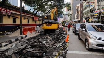 Pekerja menyelesaikan proyek pembangunan jalur pedestrian di Jalan Blora, Jakarta Pusat, Kamis (31/8/2023). [Suara.com/Alfian Winanto]