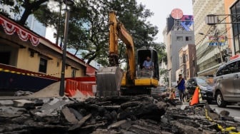 Pekerja menyelesaikan proyek pembangunan jalur pedestrian di Jalan Blora, Jakarta Pusat, Kamis (31/8/2023). [Suara.com/Alfian Winanto]