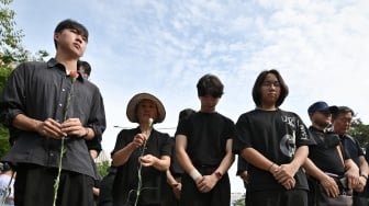 Para pengunjuk rasa mengheningkan cipta untuk seorang guru sekolah dasar yang meninggal karena bunuh diri pada bulan Juli lalu saat unjuk rasa menuntut perlindungan hak-hak guru di depan Majelis Nasional di Seoul, Korea Selatan, Senin (4/9/2023). [Yung Yeon-je / AFP]