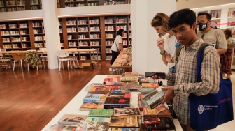 Pengunjung melihat buku saat acara Pasar Belanda di Kompleks Erasmus Huis, Jakarta, Minggu (10/9/2023). [Suara.com/Alfian Winanto]