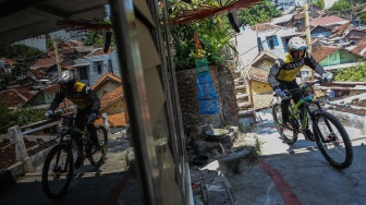 Pembalap sepeda melaju saat berusaha melewati lintasan di gang sempit dalam kejuaraan Gajahmungkur Ultimate Urban Downhill 2023 di Bendungan, Semarang, Jawa Tengah, Minggu (10/9/2023). [ANTARA FOTO/Makna Zaezar/YU]