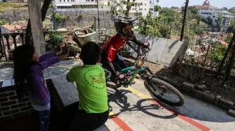 Pembalap sepeda melaju saat berusaha melewati lintasan di gang sempit dalam kejuaraan Gajahmungkur Ultimate Urban Downhill 2023 di Bendungan, Semarang, Jawa Tengah, Minggu (10/9/2023). [ANTARA FOTO/Makna Zaezar/YU]