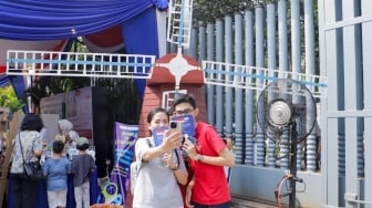 Pengunjung berswafoto saat acara Pasar Belanda di Kompleks Erasmus Huis, Jakarta, Minggu (10/9/2023). [Suara.com/Alfian Winanto]