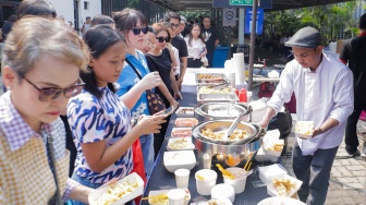 Pengunjung memilih makanan saat acara Pasar Belanda di Kompleks Erasmus Huis, Jakarta, Minggu (10/9/2023). [Suara.com/Alfian Winanto]