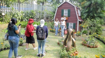 Pengunjung berswafoto dengan rumah khas Belanda saat acara Pasar Belanda di Kompleks Erasmus Huis, Jakarta, Minggu (10/9/2023). [Suara.com/Alfian Winanto]