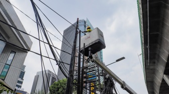 Petugas Dinas Bina Marga DKI Jakarta melakukan penataan kabel utilitas di sekitar Jalan Kapten Tendean, Jakarta, Kamis (14/9/2023). [Suara.com/Alfian Winanto]