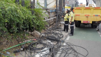 Petugas Dinas Bina Marga DKI Jakarta melakukan penataan kabel utilitas di sekitar Jalan Kapten Tendean, Jakarta, Kamis (14/9/2023). [Suara.com/Alfian Winanto]