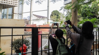 Dua orang jurnalis mengambil gambar di area pasca kebakaran Museum Nasional di Jakarta, Minggu (17/9/2023). [Suara.com/Alfian Winanto]