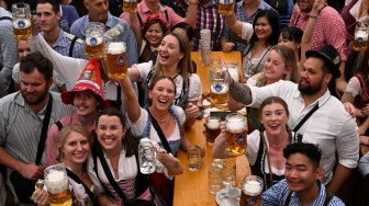 Orang-orang merayakan pembukaan festival Oktoberfest 2023 di Munich, Jerman, Sabtu (16/9/2023). [Christof STACHE / AFP]