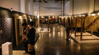 Pengunjung melihat koleksi kain batik di Museum Batik Indonesia, Taman Mini Indonesia Indah, Jakarta, Senin (2/10/2023). [Suara.com/Alfian Winanto]