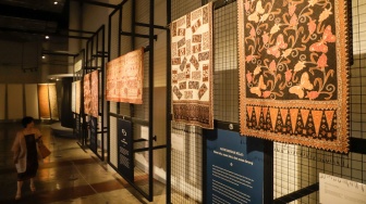 Pengunjung melihat koleksi kain batik di Museum Batik Indonesia, Taman Mini Indonesia Indah, Jakarta, Senin (2/10/2023). [Suara.com/Alfian Winanto]