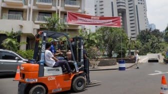 Petugas memasang spanduk peringatan di Hotel Sultan, Kompleks GBK, Jakarta, Rabu (4/10/2023). [Suara.com/Alfian Winanto]