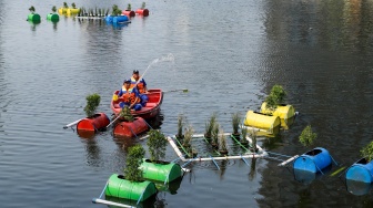 Petugas menyiram tanaman yang ada di dalam Pot Apung di Waduk Melati, Jakarta, Jumat (6/10/2023). [Suara.com/Alfian Winanto]