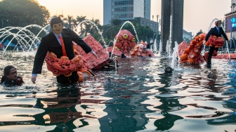 Sejumlah aktivis Greenpeace Indonesia membawa boneka gurita raksasa saat menggelar aksi kampanye tanpa oligarki di Bundaran Hotel Indonesia (HI), Jakarta, Jumat (6/10/2023). [ANTARA FOTO/Muhammad Adimaja/nym]