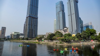 Petugas menyiram tanaman yang ada di dalam Pot Apung di Waduk Melati, Jakarta, Jumat (6/10/2023). [Suara.com/Alfian Winanto]